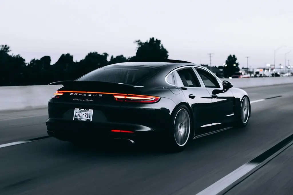 Black car travelling on a highway into the city